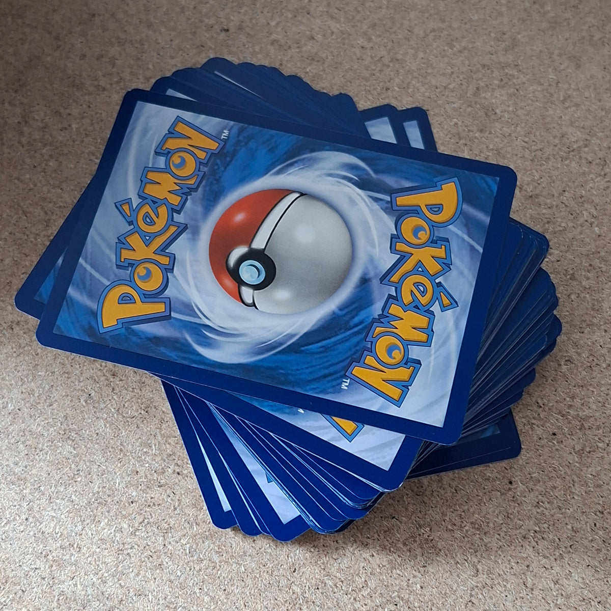 Stapel Pokémon-kaarten met de blauwe achterzijde en Poké Ball zichtbaar